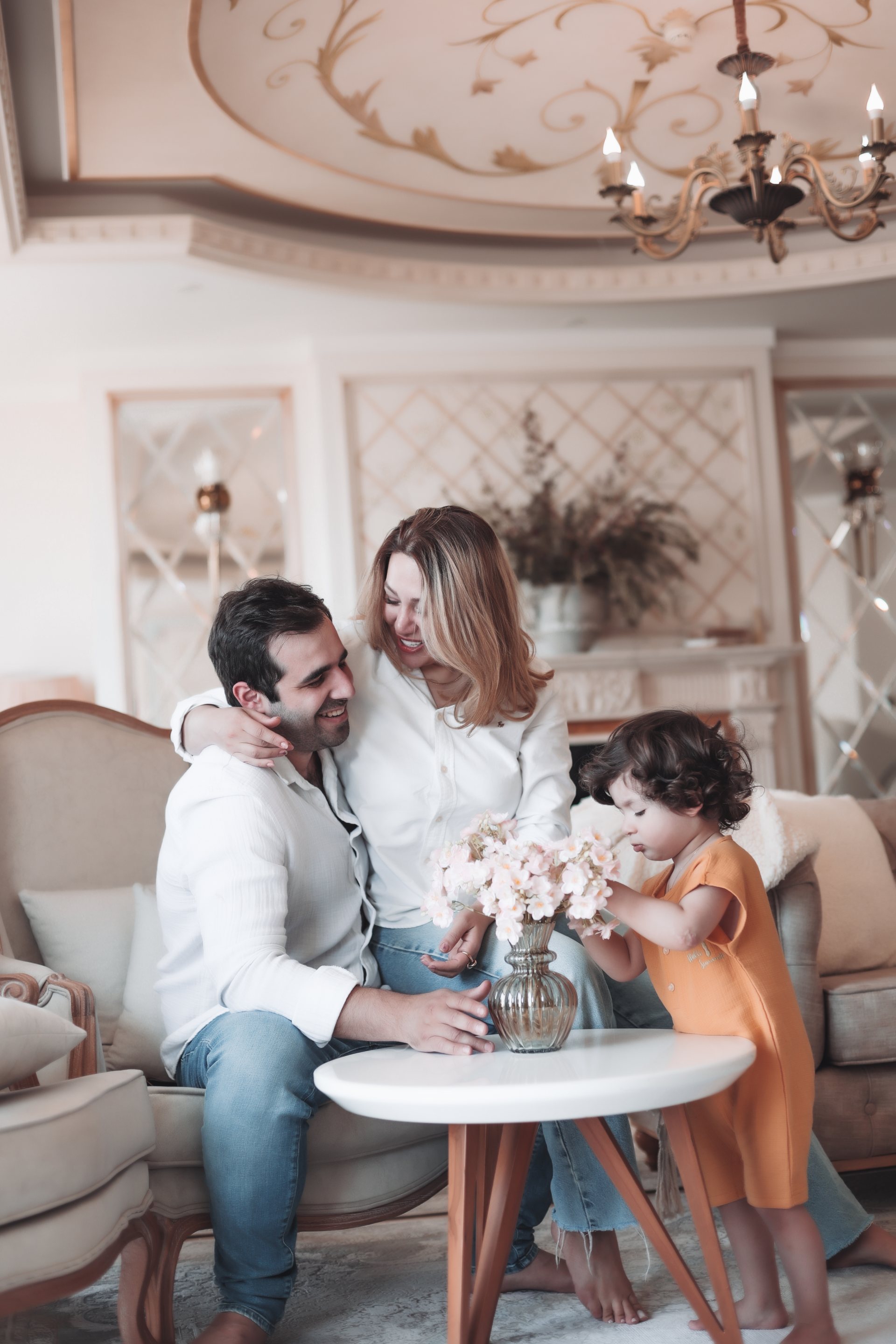 خانواده دور میز کوچک، کودک به گل‌ها خم شده