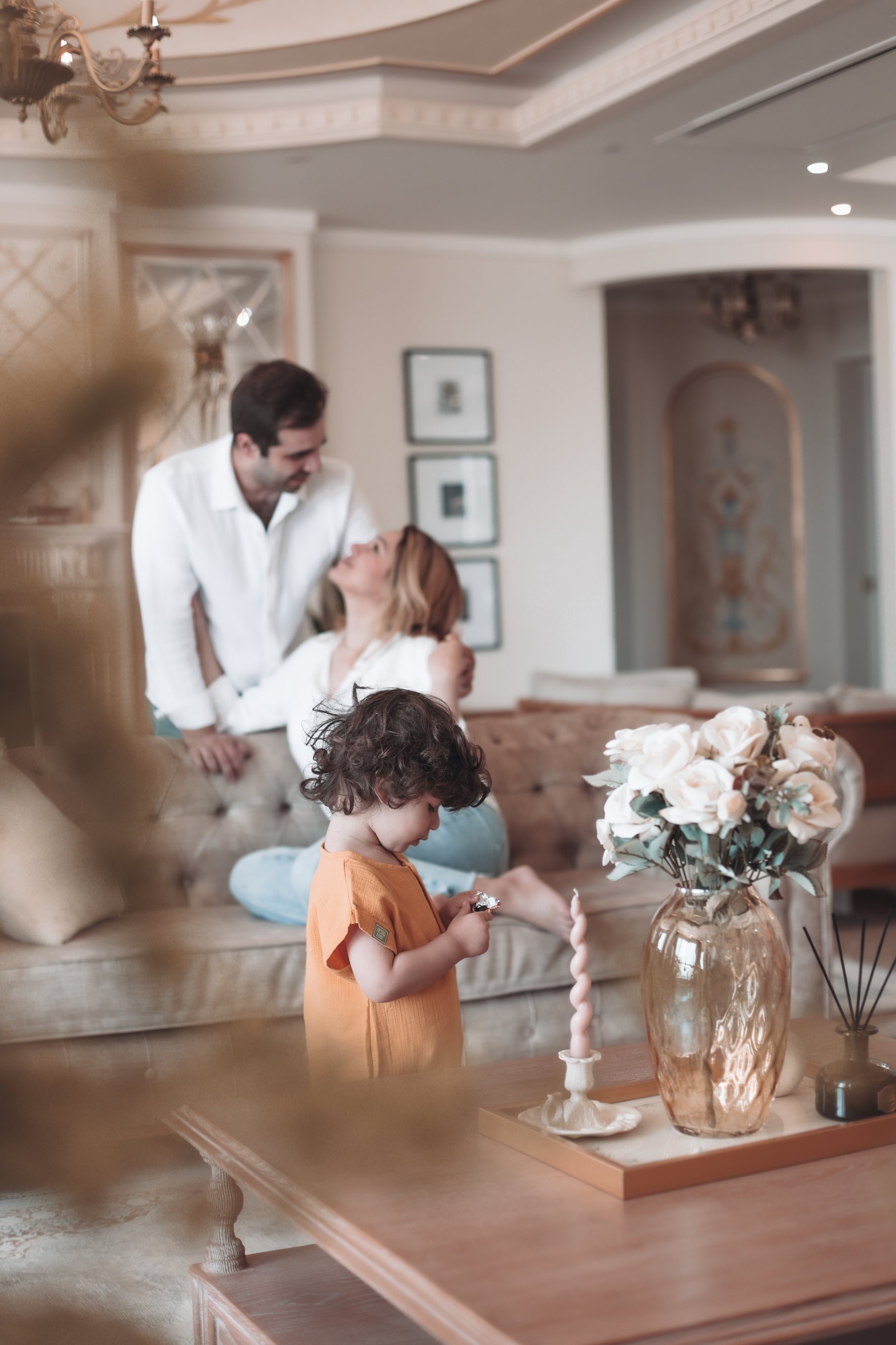 کودک کنار میز، پدر و مادر پشت سرش