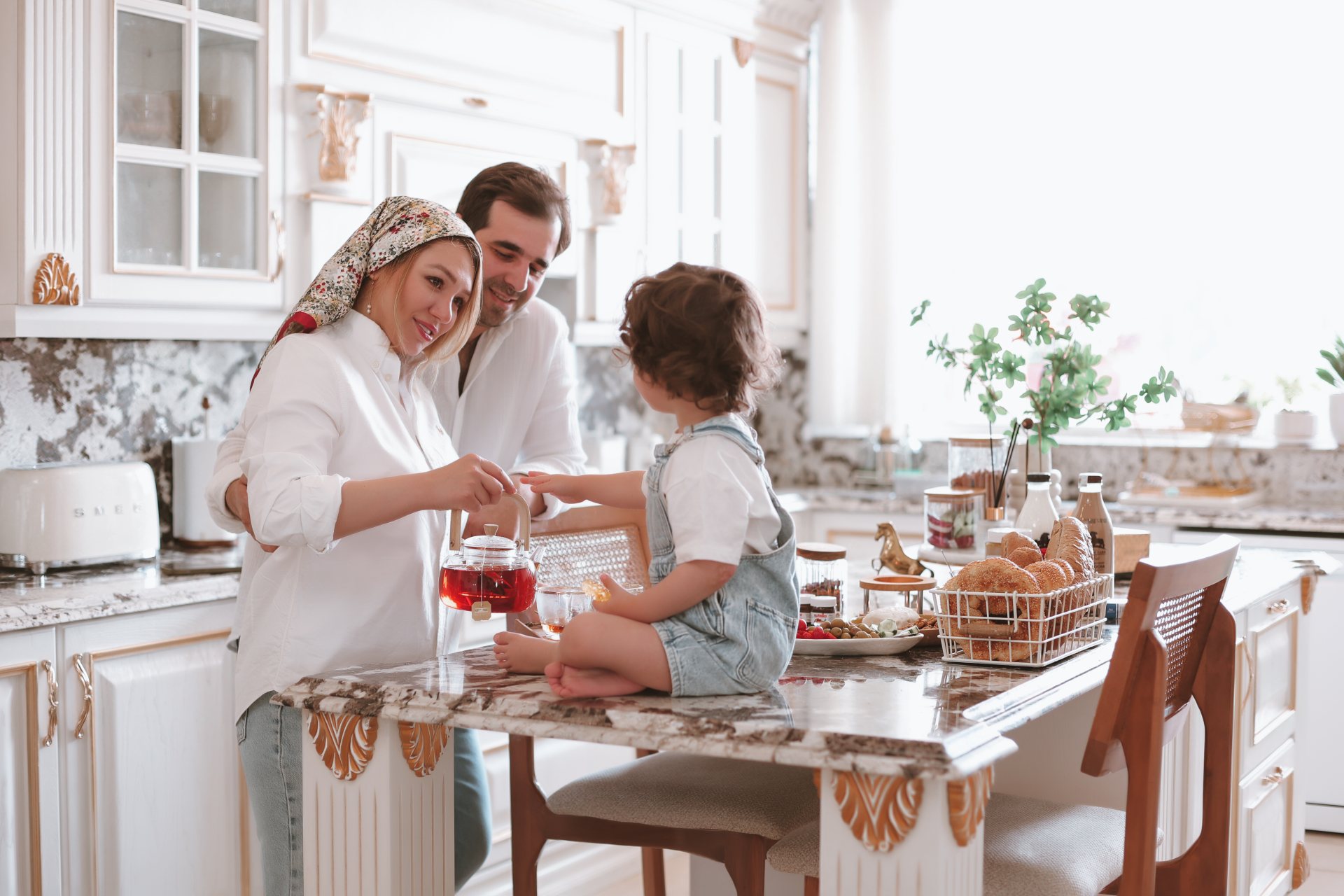 خانواده دور میز صبحانه در آشپزخانهٔ روشن