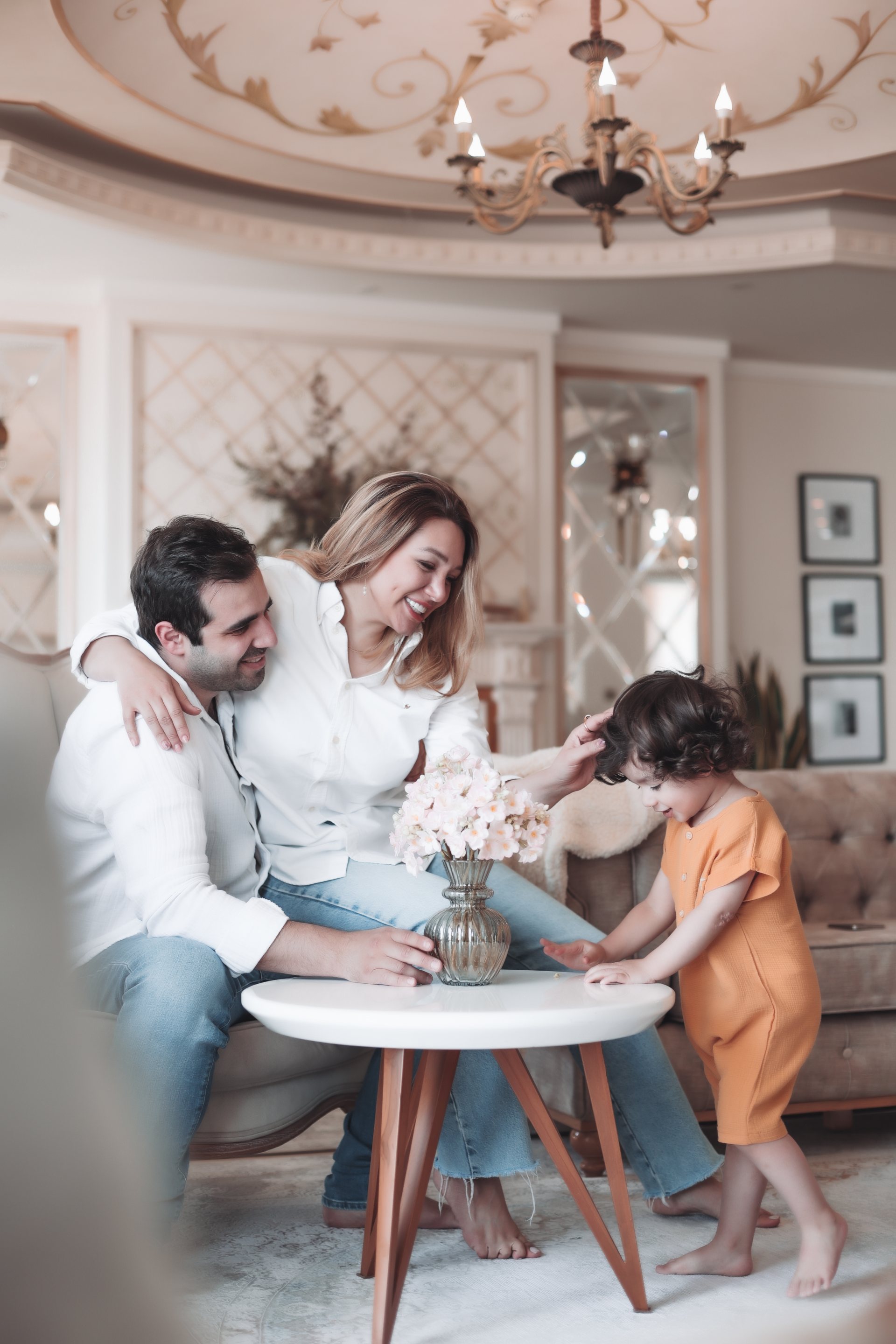 پدر و مادر نشسته، کودک کنار میز گل